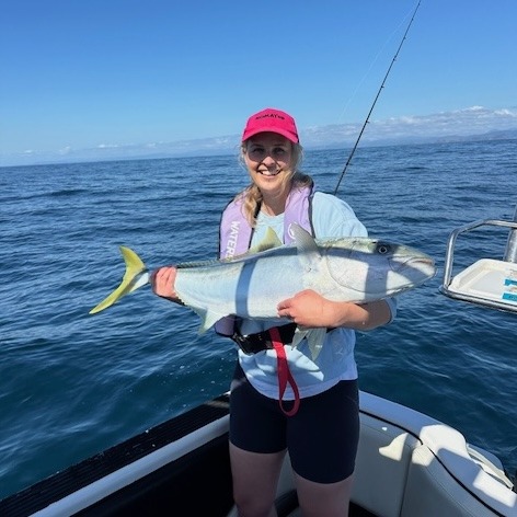 A woman holding a giant kingfish