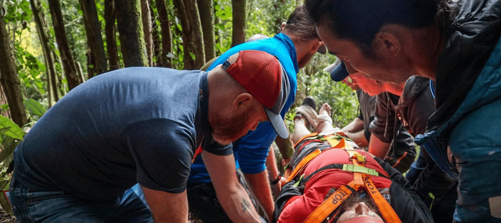 A group of people carry an injured person on a backboard for PHEC training