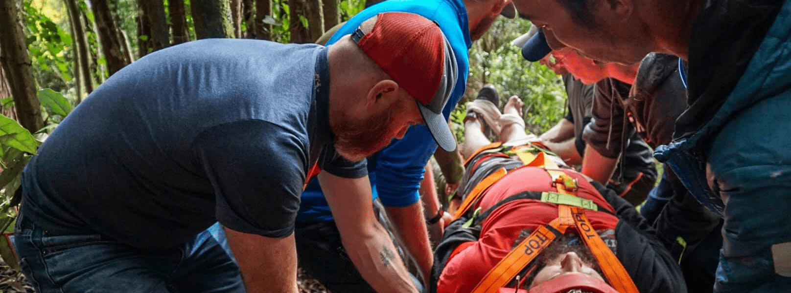 A group of people carry an injured person on a backboard for PHEC training